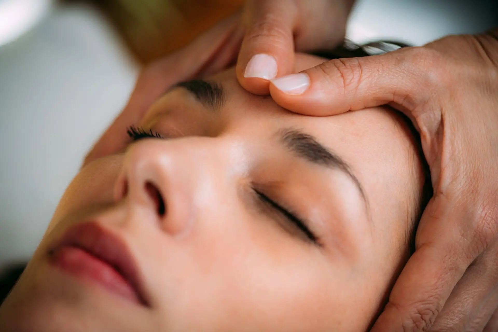 Woman receiving relaxing forehead massage