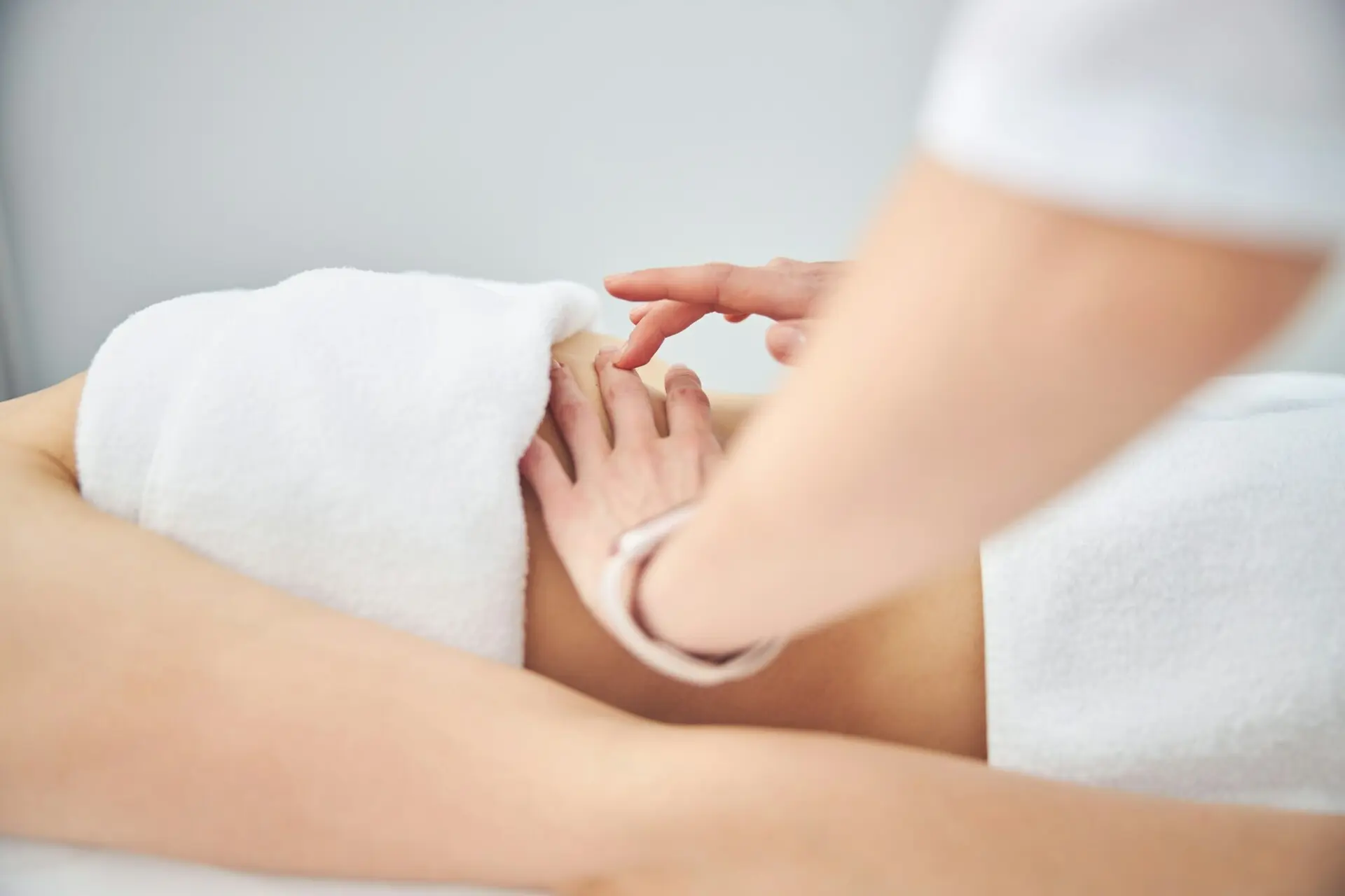 Therapist giving shoulder massage to client in spa